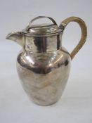 An early 20th century silver milk jug, with lid and cane covered handle, Birmingham 1901, maker's