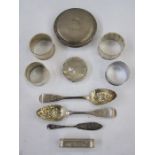 Four assorted 20th century silver napkin rings, a silver lid, a silver compact, a pair 19th