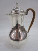 Edwardian silver hot water jug by John Henry Rawlings, London 1905, with gadrooned border and cane