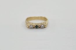18ct gold, emerald and diamond three-stone ring in modern setting, the shank with bark-finish, maker