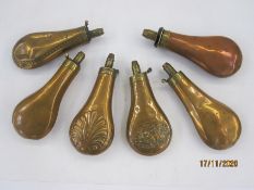 Six assorted 19th century copper and brass powder flasks, one with an embossed panel featuring a dog