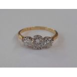 Gold graduated three stone diamond ring, marked 18ct, the central brilliant cut diamond measuring