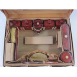Circa 1930's leather vanity case opening to a leather interior, enclosing red lacquer and inlaid