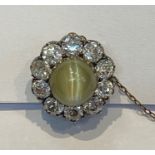 Cat’s eye chrysoberyl and diamond cluster brooch set centre cabochon green stone having surround
