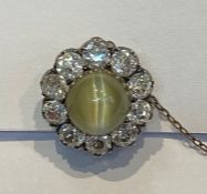 Cat’s eye chrysoberyl and diamond cluster brooch set centre cabochon green stone having surround