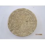 Archaeological find, a small carved stone roundel, the centre with Arabic script within a double