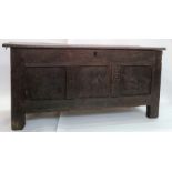 Late 18th/early 19th century oak coffer, the plain top above carved front panels, on stile supports