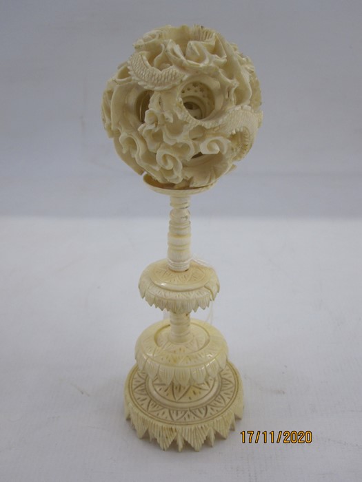 Early 20th century Chinese carved ivory puzzle ball on stand with three graduated leaf-pattern