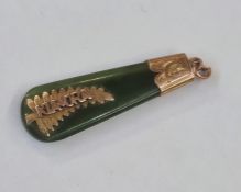 New Zealand jade pendant set with gold coloured mounts with leaf decoration inscribed 'Kia Ora'