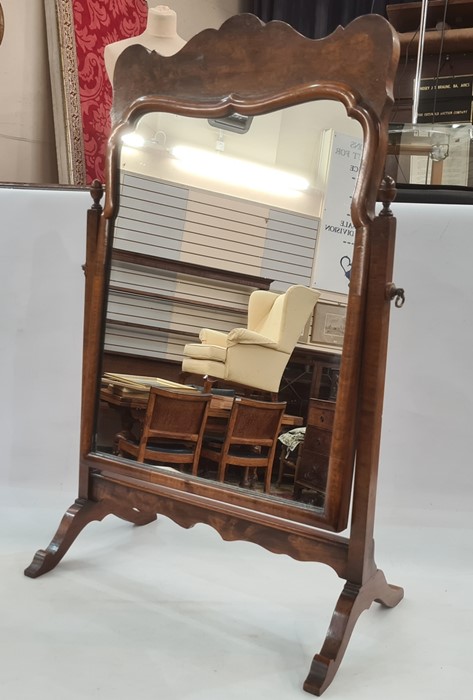 Figured mahogany toilet mirror with ogee-shaped surmount and having shaped rectangular plate, on