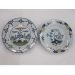 English delft plate, floral decorated and a delft plate decorated with zigzag fence in a garden,