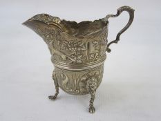 A Victorian silver cream jug, repousse decoration of dog, fox, duck, fish and partridge amongst