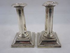 Pair of early 20th century silver-mounted candlesticks with beaded rim, octagonal tapered stem, on a