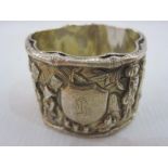Oriental silver napkin ring with relief decoration of figures in landscape riding animals,
