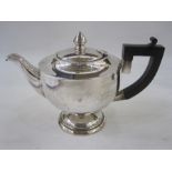 A 1920s silver tea pot, with ebonised handle, pointed finial to lid, plain circular form on a
