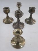 A set of four mid 20th century squat candlesticks, cup shaped holder on a tapered circular base,