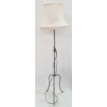 20th century wrought iron standard lamp on three cabriole supports, cream shade