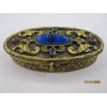 Gilt metal box of oval form, the hinged cover set with paste stones, 8cm long x 7 cms wide
