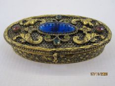 Gilt metal box of oval form, the hinged cover set with paste stones, 8cm long x 7 cms wide