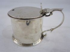 Victorian silver mustard by C Lambert, London 1897, of drum form with beaded rims and scroll handle,