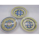 Three Delft plates, two with cross-hatch decoration in blue, red and green, with laurel to rim and