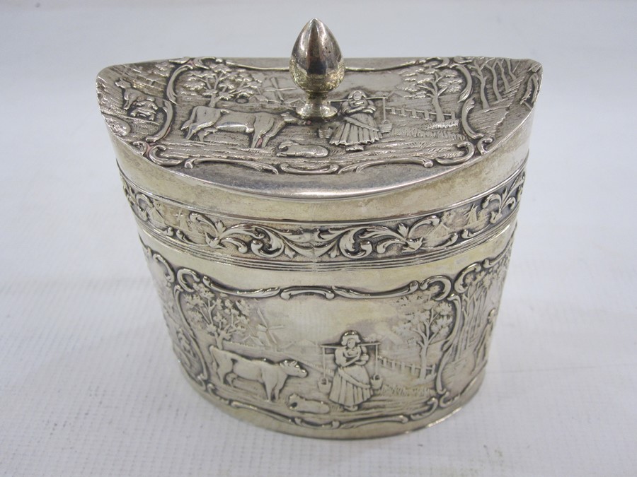 Dutch silver tea caddy with date letter for 1927 of oval form decorated with panels of rural life