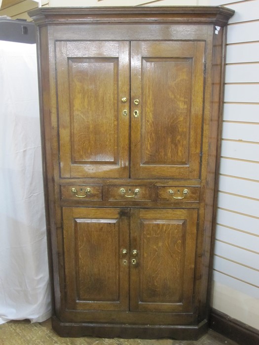 18th century oak standing corner cupboard with cavetto cornice, upper section enclosed by pair