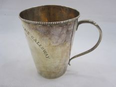 19th century white metal mug of plain tapering circular form with beaded rim and scroll handle