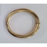 Gold hinged bangle marked 9k of twisted rib design, approx. 25.5g