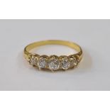 A gold and diamond five stone ring, the central diamond 4mm in diameter flanked by a pair of 3mm and