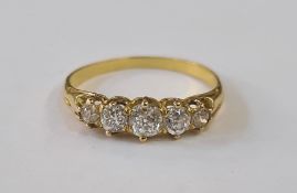 A gold and diamond five stone ring, the central diamond 4mm in diameter flanked by a pair of 3mm and