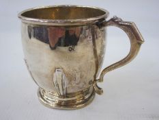 An early 20th century silver christening mug, Art Deco decoration relief to mug, shaped handle,