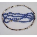 Bead necklace of tubular silver coloured beads interspaced by lapis lazuli beads and a string of