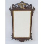 Chippendale-style mahogany and gilt wall mirror, the pierced scroll pediment with gilt bird
