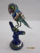 Indian silver-coloured metal and enamel polychrome model of a parrot perching on a branch, the wings