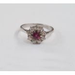 Platinum, ruby and diamond cluster ring set central circular ruby surrounded by nine diamonds,