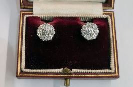 Pair diamond cluster earrings, each set in white metal, the central stone 3mm in diameter flanked by
