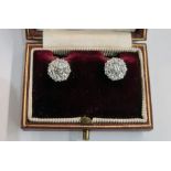 Pair diamond cluster earrings, each set in white metal, the central stone 3mm in diameter flanked by