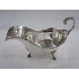 Early 20th century silver cream jug, scroll relief to rim, shaped handle and spade feet, London