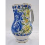 Italian faience jug decorated with scrolling flowers in a blue, green, yellow and orange palette,