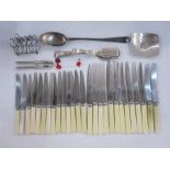 Silver plated toast rack, a pair of plated nutcrackers, a large plated rattail serving spoon and
