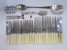 Silver plated toast rack, a pair of plated nutcrackers, a large plated rattail serving spoon and