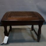 A Jacobean style oak footstool on stretchered supports. H.39 W.50 D.45cm