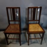 A pair of Edwardian mahogany chairs with cane seats