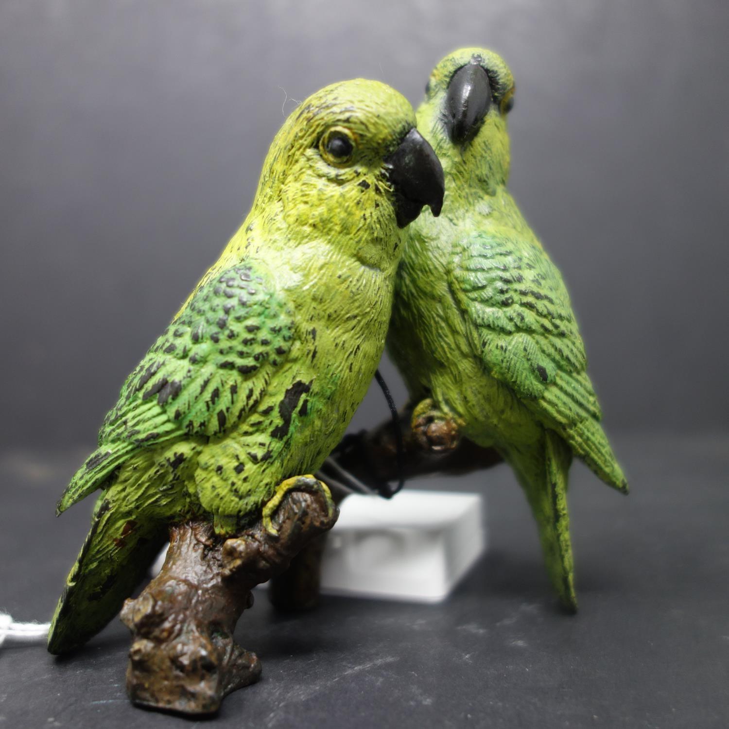 A cold painted bronze of two parrots on a branch, signed to reverse, H.10 W.10cm