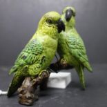 A cold painted bronze of two parrots on a branch, signed to reverse, H.10 W.10cm