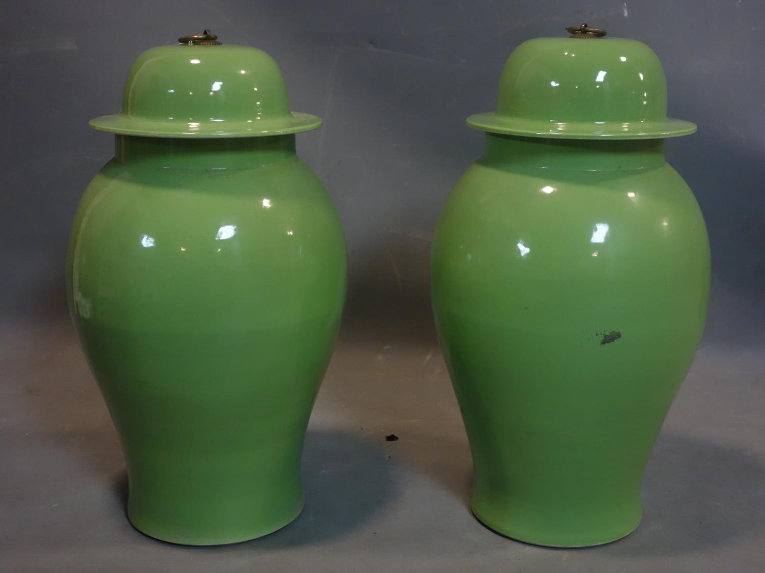 A pair of Chinese green glazed temple jars and covers, with character marks to base, H.53cm