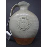 A holy water jug in stoneware with a light green glaze and decorative cartouche of virgin and