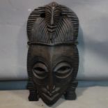 An African tribal carved wooden mask, H.60cm