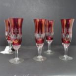 Five cranberry glass champagne flutes, H.18cm